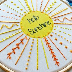 an embroidered sunburst with the words hello sunshine written in yellow and orange on it