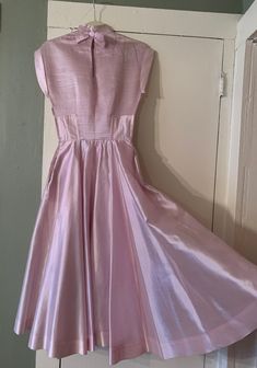 "Beautiful 1950s party dress, dreamiest iridescent pale pink color that I would almost called a faint lilac purple in certain lights as well. Though I'm not 100% certain I believe the material is a silk organza, at least partially, it's a bit heavier than a more sheer organza, but has that look and feel. So well made, high-end in both material and construction, my photos don't do it justice. Features a horizontally pin-tucked bodice, decoratively trimmed cap sleeves, mock neck, a keyhole back wi Pink Tea Length Evening Dress, Pink Tea-length Evening Dress, Spring Pink Pleated Evening Dress, Spring Party Dresses With Princess Seams, Spring Pink Evening Dress With Pleated Bodice, Pink Pleated Evening Dress For Formal Occasions, Pink Pleated Dress With Fitted Bodice, Elegant Vintage Dress With Full Skirt For Party, Elegant Pink A-line Vintage Dress