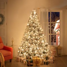 a white christmas tree with lights and presents