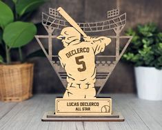 a wooden trophy with a baseball player holding a bat on it's head and the number 5