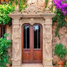 an entrance to a building with statues on the side and flowers growing up around it