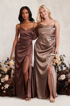 two women standing next to each other wearing dresses with thigh high slits on the sides