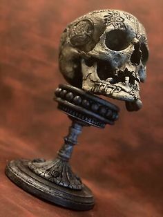 a small metal skull sitting on top of a wooden table