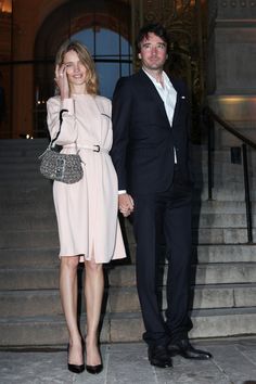 a man and woman holding hands while standing on steps