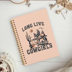 a notebook with the words long live cowgirls on it next to a cup of coffee