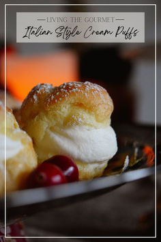 a close up of a plate of food with cream puffs and cherries on it