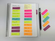 a notebook with sticky notes and a pen