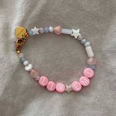 a pink and white beaded bracelet that says liven on it with star charms