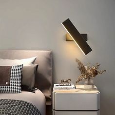 a bedroom with a bed, night stand and lamp on the side table next to it