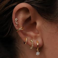 a woman wearing three different ear piercings on her left and right side of the ear