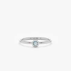 a white gold ring with a light blue diamond