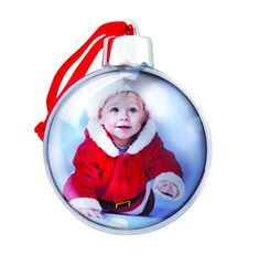 a glass ornament with a baby's photo on it and a red ribbon