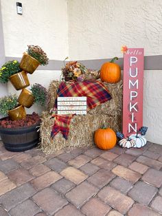 pumpkins, hay bales and other decorations are on display outside the front door