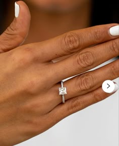 a close up of a person's hand with a ring on it and an engagement ring