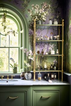 a kitchen with green cabinets and flowers on the wall, along with a gold shelving unit