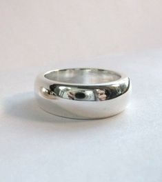 This is a beautiful, heavy sterling band ! This ring is very comfortable and makes a statement on it's own. This piece is great to wear everyday. It is ever so slightly tapered and measures 7.5mm to 8mm wide. The depth is 3mm. This ring can be custom made up to a size 8. This ring can be ordered in silver, gold and platinum. Classic Dome Ring With Polished Edges For Anniversary, Timeless Thick Band Ring For Anniversary, Timeless White Gold Thick Band Ring, Polished Dome Ring With Thick Band For Promise, Timeless Silver Dome Ring For Anniversary, Timeless Wide Band Ring With Polished Open Band, Classic Wide Band Ring For Promise, Classic Wide Band For Promise Ring, Classic Wide Band Promise Ring