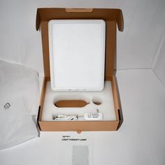 an open box with a wii remote and nunchuck in it on a white surface