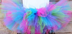 A stunning, fluffy colorful tutu with pink, purple, turquoise, and green tulle All tutus are made with high quality tulle and a 1" non-roll waist band.  I make all my tutus very full and fluffy.  I put as much tulle as I can possibly fit. Each tutu has a matching bow attached. When measuring your child's waist, order the size that is 2 inches smaller than her actual waist since the band is made of elastic. Tutu Size Chart 0-6 mo         14" waist    6"length 6-12 mo       15"waist     6"length 1 Pink Fun Tulle Tutu Dress, Fun Pink Tulle Tutu Dress, Playful Multicolor Tulle Tutu Dress, Multicolor Playful Tulle Tutu Dress, Whimsical Multicolor Tulle Tutu Dress, Multicolor Tulle Tutu Dress For Birthday, Multicolor Tulle Tutu Dress, Party Multicolor Tutu Dress With Tulle Skirt, Cute Multicolor Tulle Tutu Dress