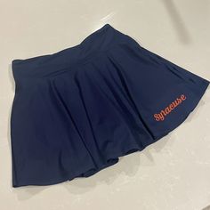 Navy and orange skirt. Perfect for tailgates or showing spirit! Zipper pocket on the back waist and built in shorts underneath. Cheerleading Mini Skirt Bottoms With Built-in Shorts, Cheerleading Mini Skirt With Built-in Shorts, Stretch Bottoms With Built-in Shorts For School, Sports Skirted Bottoms With Pockets, Sporty Skirted Bottoms With Pockets, Cheerleading Skirt With Built-in Shorts, Athletic Shorts With Elastic Waistband For Sports, Fitted Tennis Skirt With Pockets For School, Fitted Navy Skort For Sports