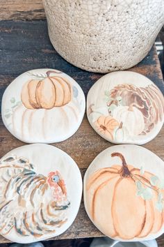 four plates with painted pumpkins on them