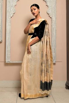 Beige tussar silk saree with all over gold, black zari handwoven checkered pattern and contrast pallu border. Comes with running blouse piece.
Components: 1
Pattern: Handwoven
Type Of Work: Floral and Checkered Pattern
Fabric: Tussar Silk
Color: Beige
Other Details: 
Handwoven
Tasselled pallu border
Saree Approx. Length: 6.4 - 6.5 mtrs
Saree Width: 45 inches
Running Blouse: 1 mtrs
Note: The stitched blouse and belt worn by the model is not for sale
Occasion: Wedding,Reception - Aza Fashions Border Saree, Tussar Silk Saree, Blouse For Women, Pattern Fabric, Handloom Saree, Checkered Pattern, Blouse Piece, Aza Fashion, Silk Saree