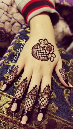 a woman's hand with henna tattoos on it