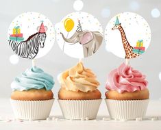 three cupcakes with blue frosting and an elephant, giraffe and zebra toppers