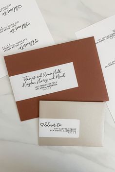 three envelopes with address cards on them