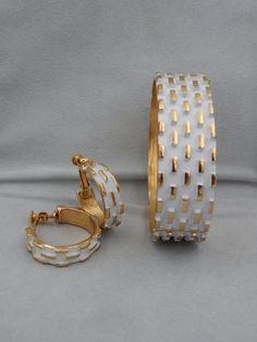 "Napier got it right in their 1973 ad for this line of jewelry \"Napier Is Groovier.\" Something about the stark white against the vibrant gold-plate makes these vintage Napier pieces art-like. The raised rectangular design on the cuff bracelet and earrings draw attention to the shape and flow of each piece. Napier designer Francis Fujio was the artistic genius during this era. His designs took the hot color for 1973, which was white, and transformed it into timeless, classical costume jewelry t Modern White Clip-on Jewelry, Classic White Metal Hoop Earrings, White Hoop Jewelry For Formal Occasions, Vintage White Metal Jewelry, Retro White Jewelry For Anniversary, White Retro Jewelry For Anniversary, White Metal Hoop Earrings For Anniversary, Anniversary White Metal Hoop Earrings, Collectible White Jewelry