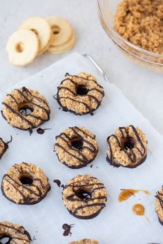 chocolate covered donuts sitting on top of a paper towel next to cookies and peanut butter