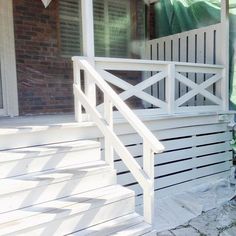 a dog is standing on the front steps of a house that has been painted white