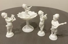 four white figurines sitting on top of a table