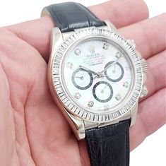 Men's Rolex Daytona 40mm Leather Band Watch with Mother of Pearl Diamond Dial and Diamond Bezel. Pre-Owned Year: 2005. Brand: Rolex. Gender: Men's. Bezel: Diamond. Type: Wristwatch. Case Size: 40mm. Condition: Excellent. Model Name: Daytona. Model Number: 116518. Band/Strap: Leather Band. Case Material: White Gold. Dial Color: Mother of Pearl. Hour Marks: Diamond Indexes. Water Resistance: 100m (10 ATM). Movement: Mechanical (Automatic). Certificate Detail: Rolex Card or Paper. Box / Certificate White Gold Leather Watch With Diamond Hour Markers, White Gold Leather Watch Accessories With Diamond Hour Markers, Silver Diamond Leather Watch For Formal Occasions, Formal Silver Diamond Watch With Leather Strap, Timeless Leather Chronograph Watch With Diamond Hour Markers, Classic Silver Diamond Watch With Leather Strap, Classic Silver Leather Diamond Watch, Designer White Gold Watches With Leather Band, Designer White Gold Leather Watch