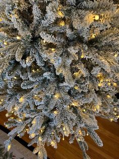 the top view of a christmas tree with white lights and snow flakes on it