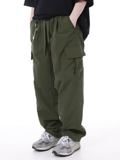 It is string cargo pants with the 100% nylon fabric. You can adjust the size with the waist string. You can wear it casually. - Wide fit - Waist banding- Pin tuck detail on the front thigh- Cargo pockets- Stopper on the hem Utility Khaki Cargo Pants With Elastic Waistband, Utility Cargo Pants With Elastic Waistband In Khaki, Casual Khaki Parachute Pants With Drawstring, Casual Green Cargo Pants With Drawstring, Utility Khaki Bottoms With Functional Drawstring, Urban Style Khaki Parachute Pants With Cargo Pockets, Techwear Khaki Parachute Pants With Cargo Pockets, Khaki Techwear Parachute Pants With Cargo Pockets, Urban Style Khaki Parachute Cargo Pants