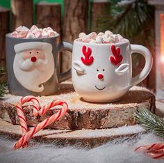 two mugs filled with hot chocolate and candy canes