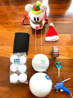 an assortment of holiday items laid out on a wooden floor with santa hats and other decorations