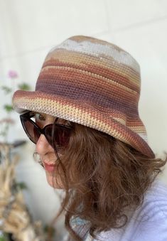 This beautiful  crochet bucket hat is made with a premium cotton mix in a scheme of pastel colors of brown and cream.  It's a very stylish accesory for summer time; chic, soft and comfortable. It's a great sun visor in your daily use, at the beach and at fun places like summer festivals. The material is very soft and firm at the same time; fits very well and feels very comfortable on the head. It is so flexible that you can shape and use the brim differently as you wish. SIZE: M / L ------ * Cir Brown Crochet Hat For Summer, Brown Knitted Cotton Hat, Brown Brimmed Cotton Bucket Hat, Summer Brown Yarn Bucket Hat, Brown Crochet Bucket Sun Hat, Knitted Brown Brimmed Bucket Hat, Handmade Brown Bucket Hat For Spring, Handmade Casual Brown Crochet Hat, Handmade Brown Crochet Hat Casual Style