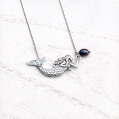 Quintessentially playful yet elegant, the dazzling Mermaid Necklace makes for a stunning accessory – at the beach, on the water, in the office, or out on the town. It’s the perfect gift for the beach lover in your life. Details: Mermaid: Eco-friendly Alloy, 40mm(L) x 22mm(W)Natural Black Fresh Water PearlAdjustable Cable Chain: Stainless Steel, 20''+2'' Extension Sunshine on your neck, the ocean in your ears. Discover GoBeachy jewelry - where summer never fades. Dive into sun-kissed sparkle, whe Ocean-inspired Pearl Pendant Necklaces As Gifts, Ocean-inspired Shell Necklace With Lobster Clasp For Gift, Silver Clavicle Chain Jewelry For Beach, Ocean-inspired Sterling Silver Necklaces, Ocean-inspired Pearl Pendant Jewelry, Sterling Silver Ocean-inspired Necklaces, Mermaid Charm Necklace With Lobster Clasp For Gift, Ocean-inspired Adjustable Necklace As A Gift, Elegant Mermaid Jewelry With Lobster Clasp