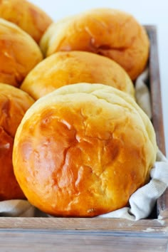 some bread rolls are in a wooden box