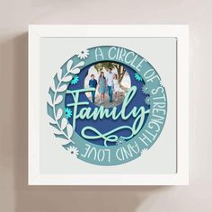 a family photo hanging on the wall in front of a white frame with blue lettering