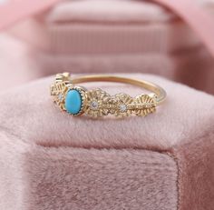 a gold ring with a turquoise stone in it