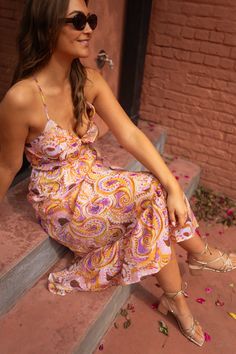 This purple and yellow paisley-patterned dress features a V-neck, drawstrings to tie, and an open back. An inner lining and flowy silhouette make this dress a perfect mix of both chic and comfort. Sizes: S-M / M-L S-M: Length 47.64 in - Width 12.2 in M-L: Length 48.43 in - Width 12.99 in 70% viscose - 30% polyester Washing: handwash only V-neck Midi Dress With Paisley Print For Summer, V-neck Midi Dress With Paisley Print For Beach, V-neck Paisley Print Midi Dress For Beach, Beach Sundress With Paisley Print And V-neck, Bohemian V-neck Midi Dress With Tie Back, Flowy Paisley Print Midi Dress For Vacation, Flowy Midi Dress With Paisley Print For Vacation, Summer Paisley Print Maxi Dress For Brunch, Flowy Paisley Print Midi Dress For Beach