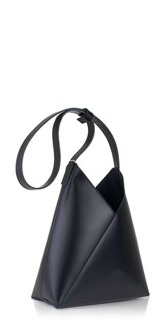 Introducing the Fortune Cookie Leather Shoulder Bag by MM6 Maison Margiela. This bag offers a modern twist on the iconic Japanese Triangle style. Crafted from soft black leather, it can be worn as a shoulder or top handle bag with its unique snap feature. Its fortune cookie-inspired design adds a playful touch to any outfit. Details: Color: Black 100% leather Magnetic snap closure Adjustable strap Interior slip pocket Vendor Code: SB6ZH0019P7183T8013 Modern Structured Bags In Soft Leather, Modern Structured Soft Leather Bag, Contemporary Top Handle Leather Bag, Contemporary Leather Top Handle Bag, Contemporary Black Formal Bags, Contemporary Leather Shoulder Bag For Daily Use, Modern Soft Leather Bucket Shoulder Bag, Black Structured Leather Bag, Modern Structured Leather Hobo Bag