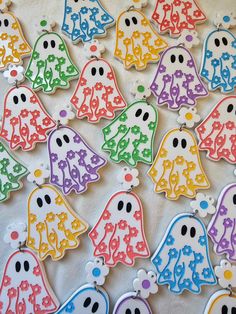 many decorated cookies are arranged in the shape of ghost faces and dots on white paper