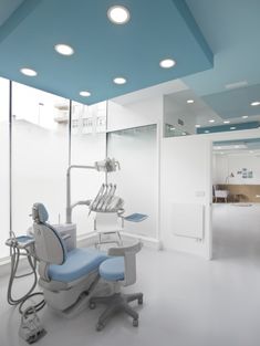 an empty dental room with blue and white accents on the ceiling, lights in the windows