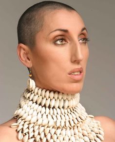 a woman wearing a white necklace and earrings