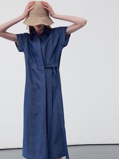 This product is a belted midi shirt dress that offers a versatile and contemporary take on the classic shirt dress. The piece features a pointed collar and a front button closure that runs the length of the dress, allowing for a customizable fit. The addition of a belt emphasizes the waist, while the midi length strikes an elegant balance between casual and formal. - The dress's side slits provide freedom of movement and a touch of allure.- Its roll-up sleeve design adds a casual, effortless look, suitable for different seasons.- The lightweight fabric ensures comfort and breathability throughout the day.- This midi shirt dress can be dressed up with heels or down with flats, making it a staple for any occasion. Fitted Belted Dress With Button Closure For Spring, Classic Belted Collared Dress, Classic Fitted Collared Belted Dress, Chic Collared Dress With Belt, Spring Shirt Dress With Tie Waist And Relaxed Fit, Fitted Belted Button-up Shirt Dress, Spring Relaxed Fit Shirt Dress With Tie Waist, Fitted Collared Belted Dress For Work, Fitted Belted Shirt Dress For Work