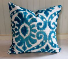 a blue and white pillow sitting on top of a bed