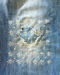 the back pocket of a pair of jeans with snowflakes on it and holes in the fabric